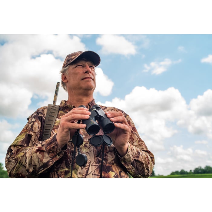 A Man Holding Alpen Apex 8x42mm Binocular Outdoors