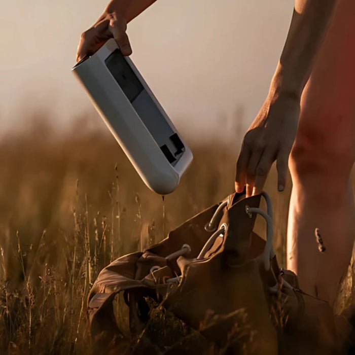 A Man Holding Vaonis Hestia Smartphone-Based Telescope - Ultimate Pack and a Bag