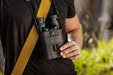 A Man Holding the Kite Optics 16x42mm ED APC Stabilized Binoculars - Lifestyle Photo Outdoors