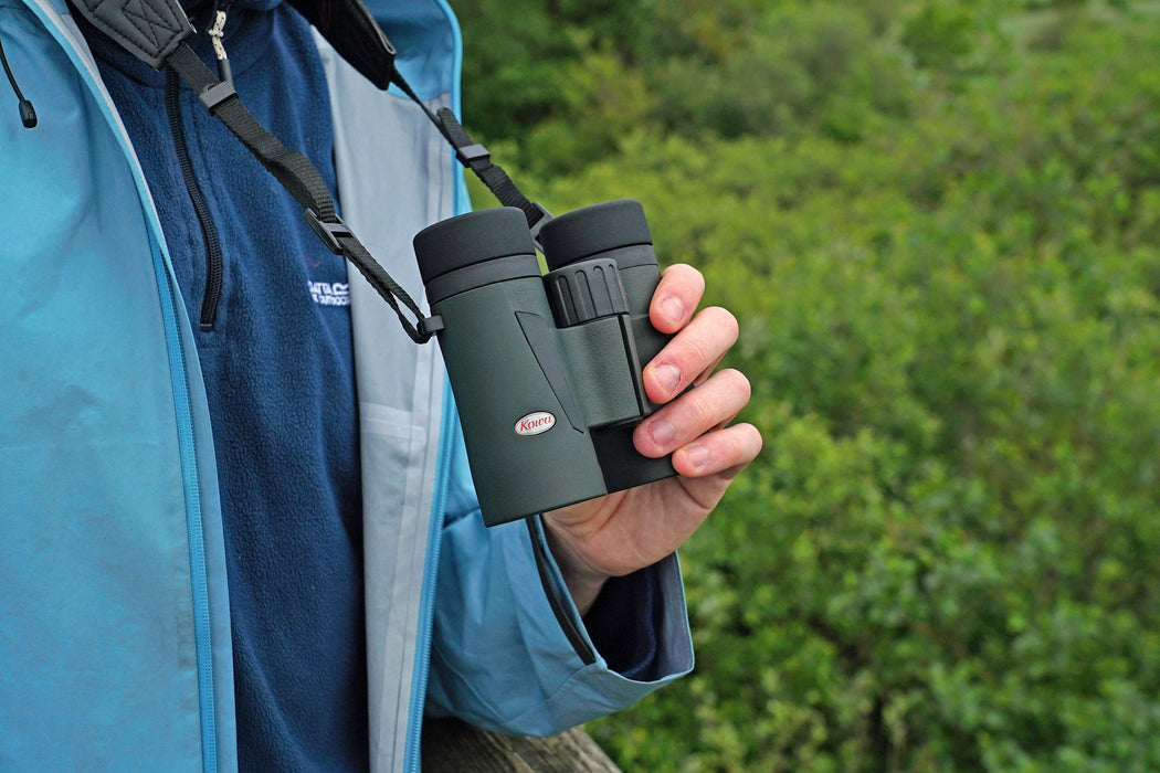 A Man Holding the Kowa BD III-XD 10x32mm Binocular with Neck Strap - Lifestyle Photo