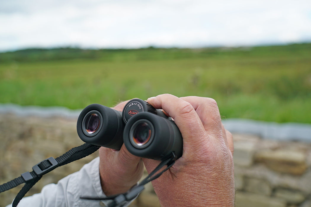 A Man Holding the Kowa BD III-XD 10x42mm Binocular - Lifestyle Photo Outdoor