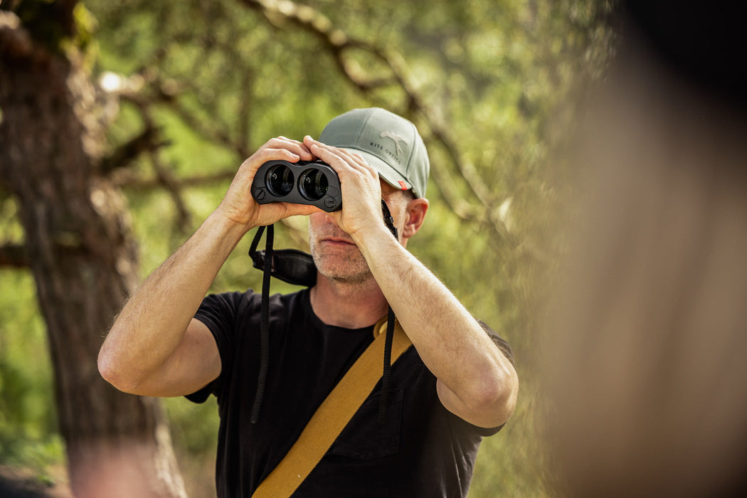 A Man Using the Kite Optics 16x42mm ED APC Stabilized Binoculars - Lifestyle Photo Outdoors