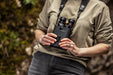 A Woman Holding the Kite Optics 12x42mm ED APC Stabilized Binoculars - Lifestyle Photo Outdoors