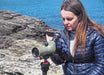 A Woman Using Kowa TSN-553 15-45x55mm Angled Spotting Scope with Mobile Phone