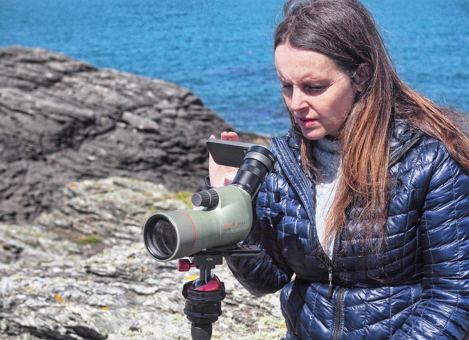 A Woman Using Kowa TSN-553 15-45x55mm Angled Spotting Scope with Mobile Phone
