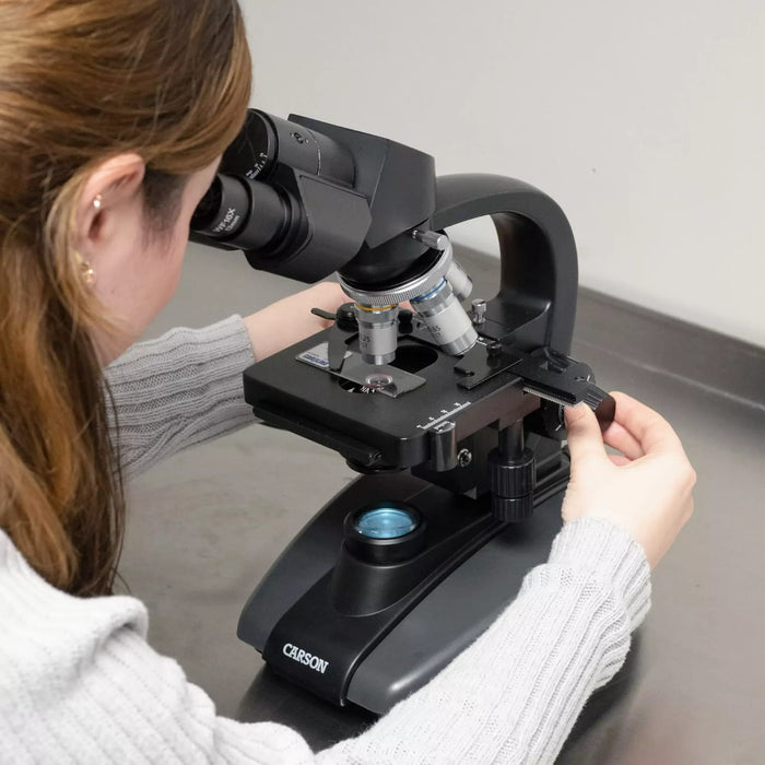 A Woman Using the Carson 40x-1600x Professional Grade Biological Microscope