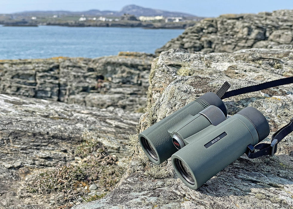 Kowa BDII-XD 8x32mm Prominar Roof Prism Wide Angle Binocular leaning on a rock outdoors