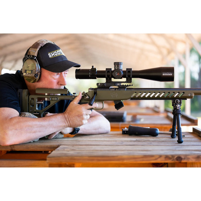 Sightron S6 10-60x56mm ED MOA-BD Bench Rest Riflescope - Bench Rest Shooter Aiming a Rifle with Sightron Riflescope at an Outdoor Shooting Range